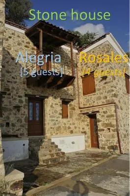 a stone house with a sign on the side of it at Rosales stone house in AmigdhalokeFálion