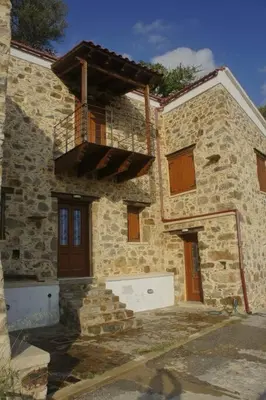 a stone building with a balcony on the side of it at Rosales stone house in AmigdhalokeFálion