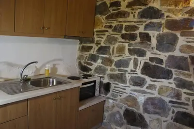 a kitchen with a stone wall and a sink at Rosales stone house in AmigdhalokeFálion