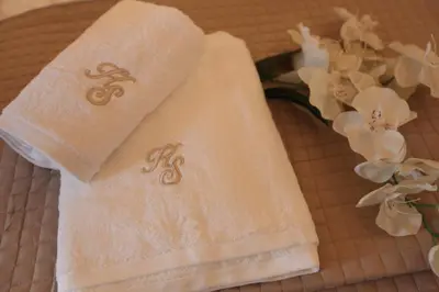 a pair of towels sitting on a table with flowers at Kabanas 2 luxury Suite in Chania Town