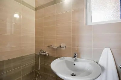 a bathroom with a white sink and a window at Patelakis Apartment near the Beach in Chania Town