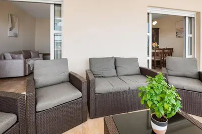 a living room with wicker chairs and a couch at Patelakis Apartment near the Beach in Chania Town
