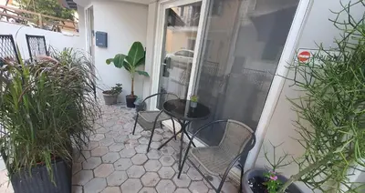 a patio with chairs and a table and potted plants at Black Suites in Chania Town