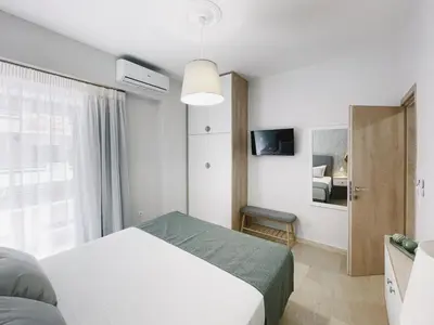 a white bedroom with a bed and a window at Urban Hive Chania, Your City Basecamp - Fiber Wifi in Chania Town