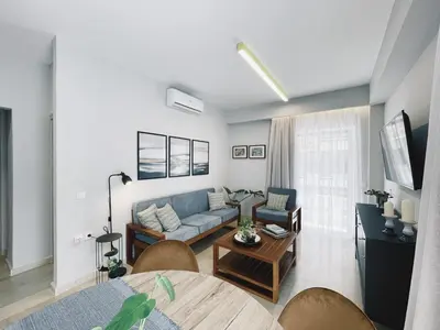 a living room with a blue couch and a table at Urban Hive Chania, Your City Basecamp - Fiber Wifi in Chania Town
