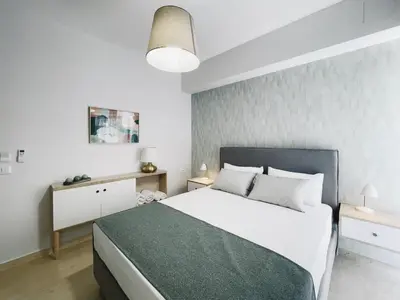 a bedroom with a large bed with a green blanket at Urban Hive Chania, Your City Basecamp - Fiber Wifi in Chania Town