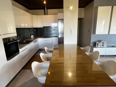 a kitchen with a wooden table and white chairs at blue and green II in Chania Town