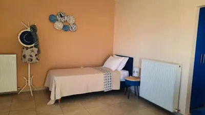 a bedroom with a bed and a clock on the wall at Elena Apartments in Kato Daratso