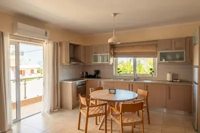 a kitchen with a table and chairs and a window at Elena Apartments in Kato Daratso