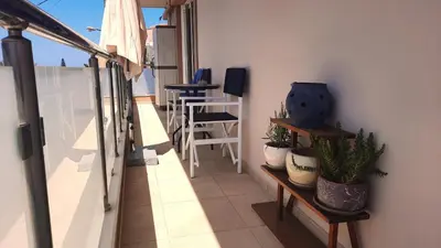 a balcony with plants and a table and chairs at Elena Apartments in Kato Daratso