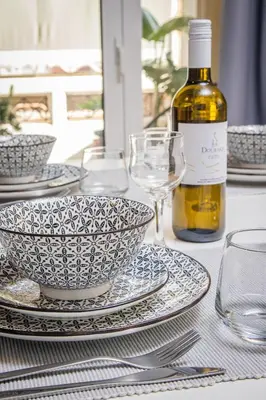 a table with plates and glasses and a bottle of wine at Easy Living City Apartment in Chania Town