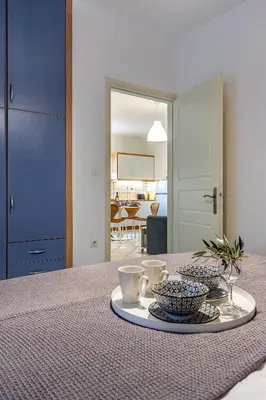 a table with a tray with bowls and cups on it at Easy Living City Apartment in Chania Town
