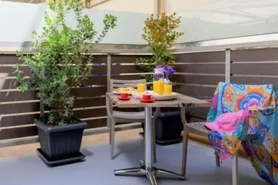 a table and chairs on a patio with plants at Ginger Chania City Center Apartment in Chania Town