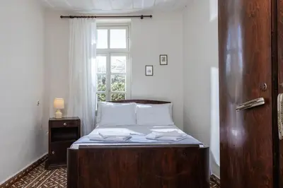 a bed with a wooden frame in a room with a window at Argiro's House - Chania Old Town in Chania Town