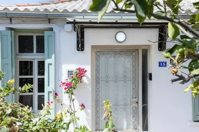 a white house with a blue door and flowers at Argiro's House - Chania Old Town in Chania Town
