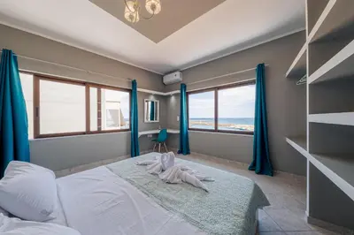 a bedroom with a bed with blue drapes at Luxury Sea View Apartment in Kolimvari in Kolymvari
