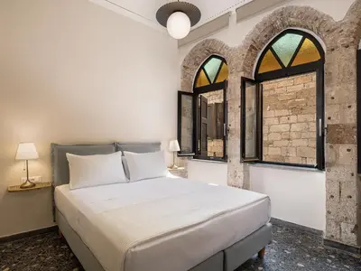 a bedroom with a bed and two windows at Faedra Residence in Chania Town