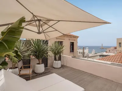 a patio with an umbrella and plants on a balcony at Faedra Residence in Chania Town