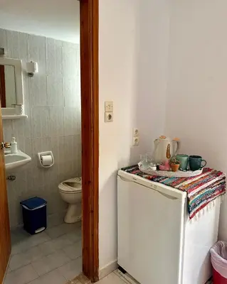 a small bathroom with a toilet and a refrigerator at BONATSA ROOMS in Palaiochóra