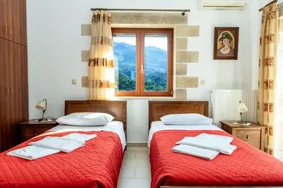 two beds in a room with a window at Ktima Edem in Ramní