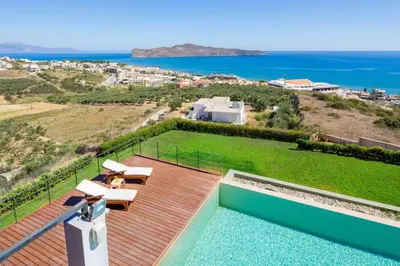 a house with a pool and a view of the ocean at Villa Pasiphae in Stalos