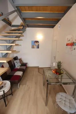 a living room with a couch and a staircase at Kabanas 3 cosy suite in Chania Town