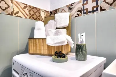 a bathroom with towels and a basket on top of a washing machine at Apartments Panethimos in Panéthimos