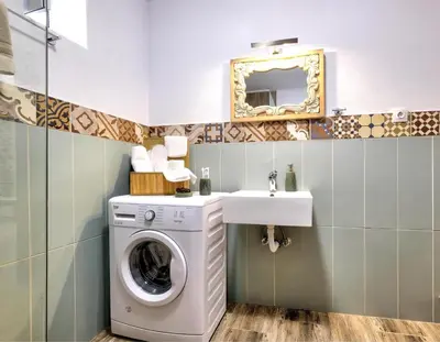 a bathroom with a washing machine and a sink at Apartments Panethimos in Panéthimos