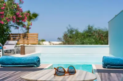 a pair of sunglasses sitting on a surfboard next to a swimming pool at Natura Hill Villa III Sunset View in Kounoupidhianá