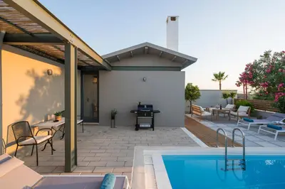 a patio with a swimming pool and a house at Natura Hill Villa III Sunset View in Kounoupidhianá