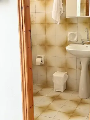 a bathroom with a sink and a toilet at wave rooms sea view in Maleme