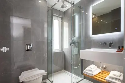 a bathroom with a shower and a toilet and a sink at Epavli Grace Hotel in Chania Town