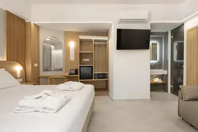 a hotel room with a bed with towels on it at Epavli Grace Hotel in Chania Town