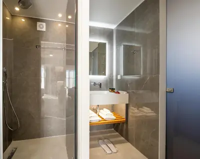 a bathroom with a shower and a sink at Epavli Grace Hotel in Chania Town