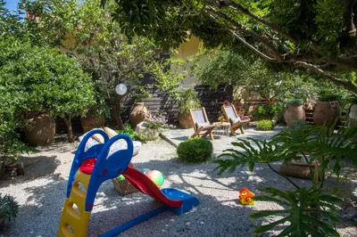 a garden with a playground with a plastic toy at Evangelos Apartments in Plataniás