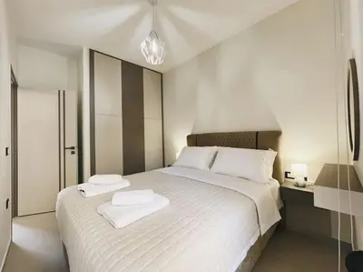 a bedroom with a white bed with two towels on it at Comfy Corner Luxury Apartment in Chania Town