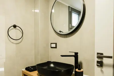a bathroom with a black sink and a mirror at Comfy Corner Luxury Apartment in Chania Town