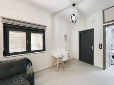 a living room with a black door and a desk at Comfy Corner Luxury Apartment in Chania Town