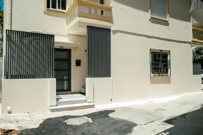 a white building with a door and a window at Comfy Corner Luxury Apartment in Chania Town