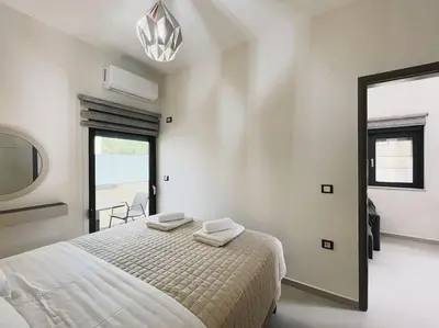 a white bedroom with a bed and a mirror at Comfy Corner Luxury Apartment in Chania Town
