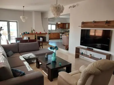 a living room with a couch and a table and a tv at Passatempo Casa - 3 bedroom apartment close to the swimming pool in Gerani Chanion