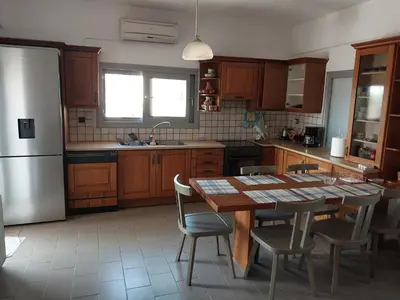 a kitchen with a table and chairs and a refrigerator at Passatempo Casa - 3 bedroom apartment close to the swimming pool in Gerani Chanion