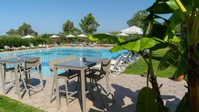 a table and chairs next to a swimming pool at Passatempo Casa - 3 bedroom apartment close to the swimming pool in Gerani Chanion