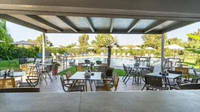 a patio with tables and chairs and a pool at Passatempo Casa - 3 bedroom apartment close to the swimming pool in Gerani Chanion
