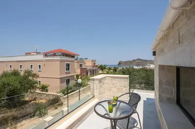 a balcony with a table and a view of a building at Megalith Villas in Agia Marina Nea Kydonias