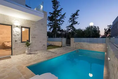 a swimming pool in the backyard of a house at Megalith Villas in Agia Marina Nea Kydonias
