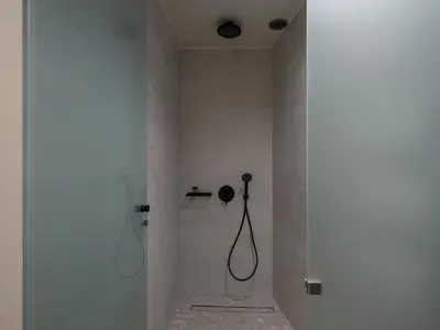a bathroom with a shower with a hose on the wall at Ares Luxurious Residence in Kolymvari