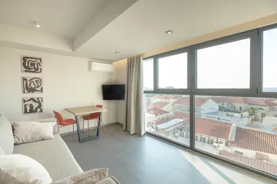 a living room with a couch and a large window at Sky-High Central Penthouse w. Stunning Views - 01 in Chania Town
