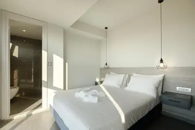 a bedroom with a white bed and a bathroom at Sky-High Central Penthouse w. Stunning Views - 01 in Chania Town