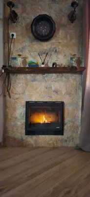 a stone fireplace with a fire in it at 4Seasons in Chania Town